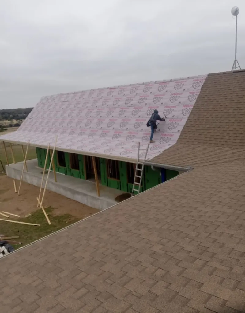 Worker preparing underlayment for a metal roof installation in Chapel Hill